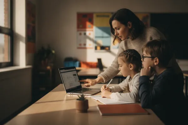 Teacher with a laptop guiding students